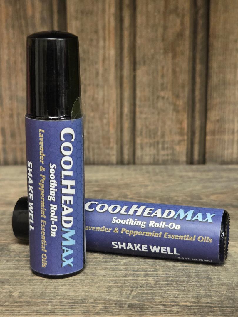 Two CoolHeadMax soothing roll-on bottles on a wooden surface