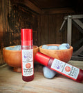 Red bottles of Susan's Energize and Focus roll on in front of blue quartz crystals on a rustic background