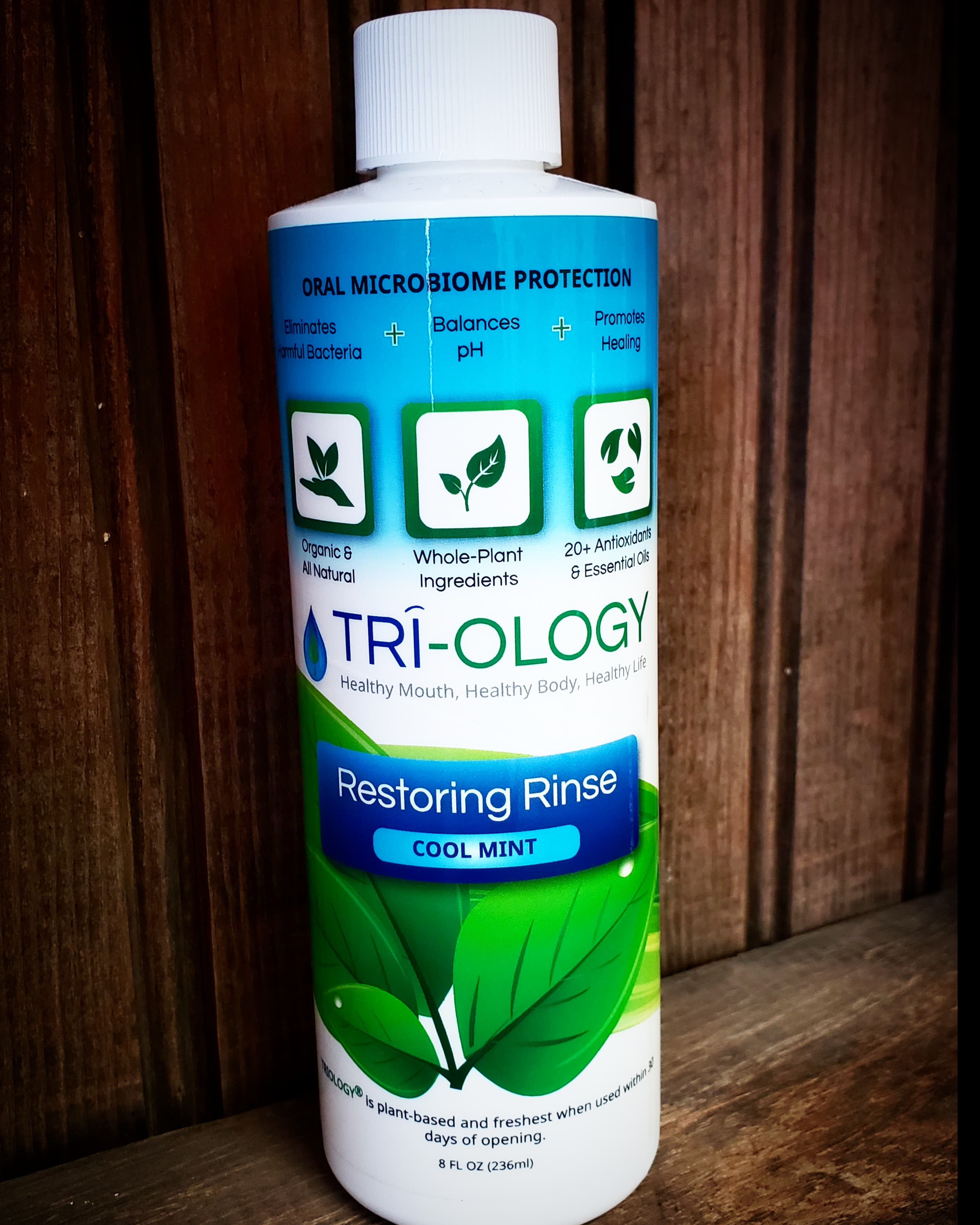 Bottle of Triology Restoring Rinse with cool mint flavor, highlighting its microbiome-protective properties and organic ingredients.