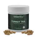Bottle of Verdant Leaf Turkey Tail with capsules scattered in front on a white backgound